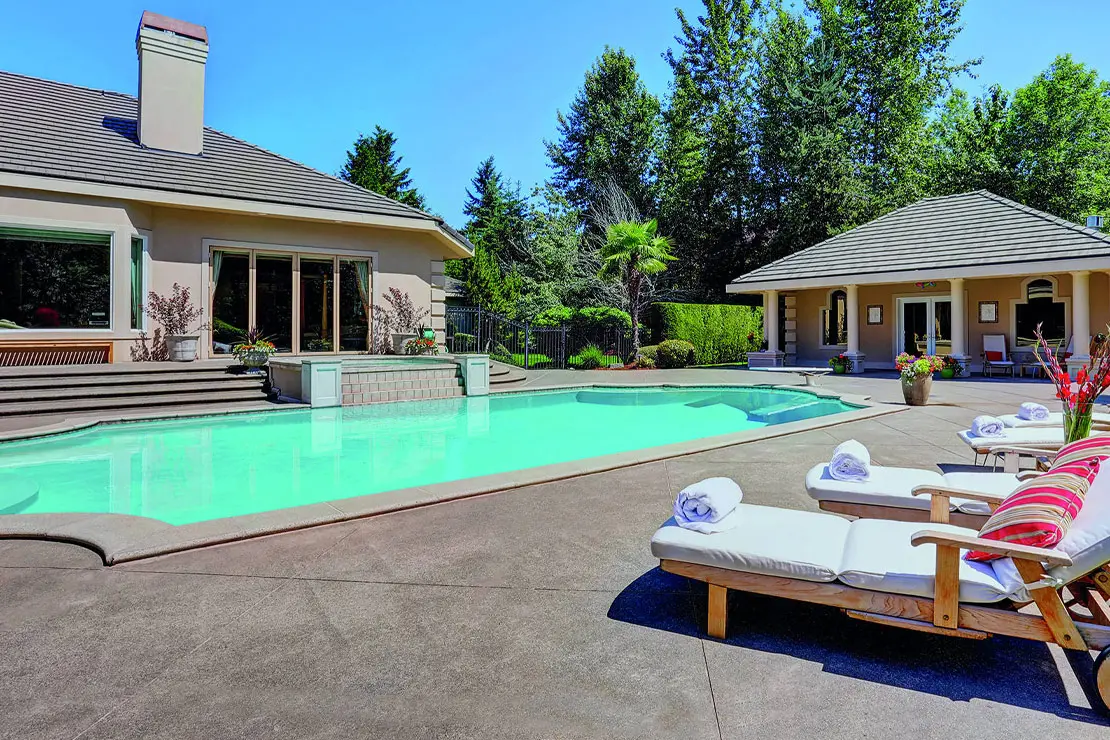 Casa con impresionante piscina pavimentada con hormigón estampado